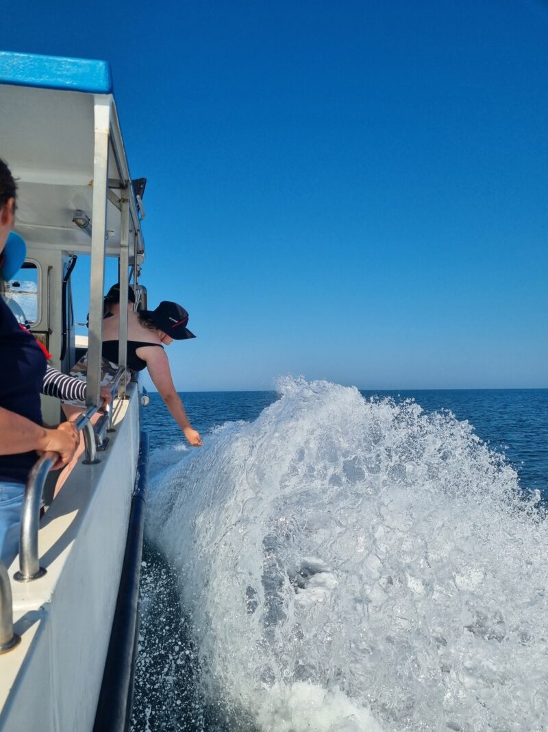 The Obsession II sending waves of sea spray towards the Young Carers who are enjoying the boat trip